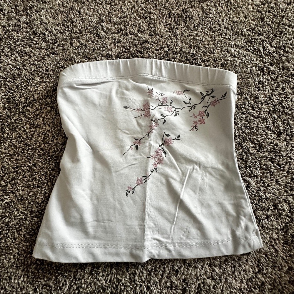 Light grey tube top adorned with a small flowery patch.